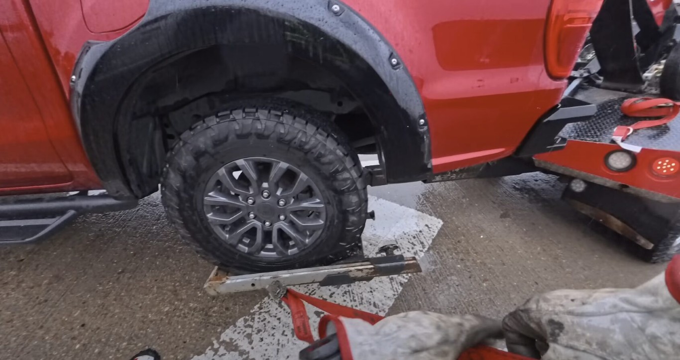 Truck with flat tire being secured on a tow truck in Solana Beach, CA