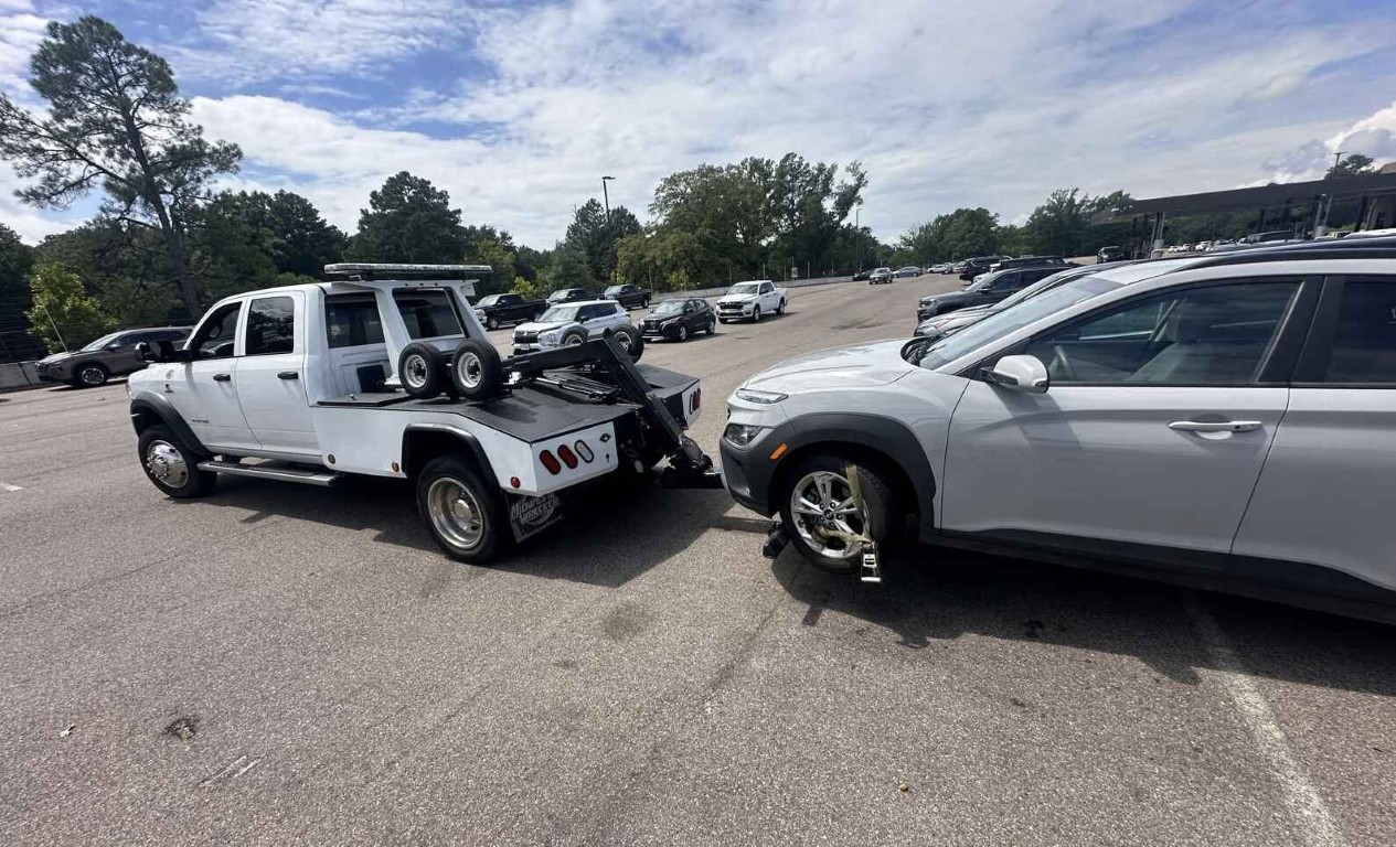 Emergency tow truck hooking up an SUV in a parking lot in Cardiff, CA